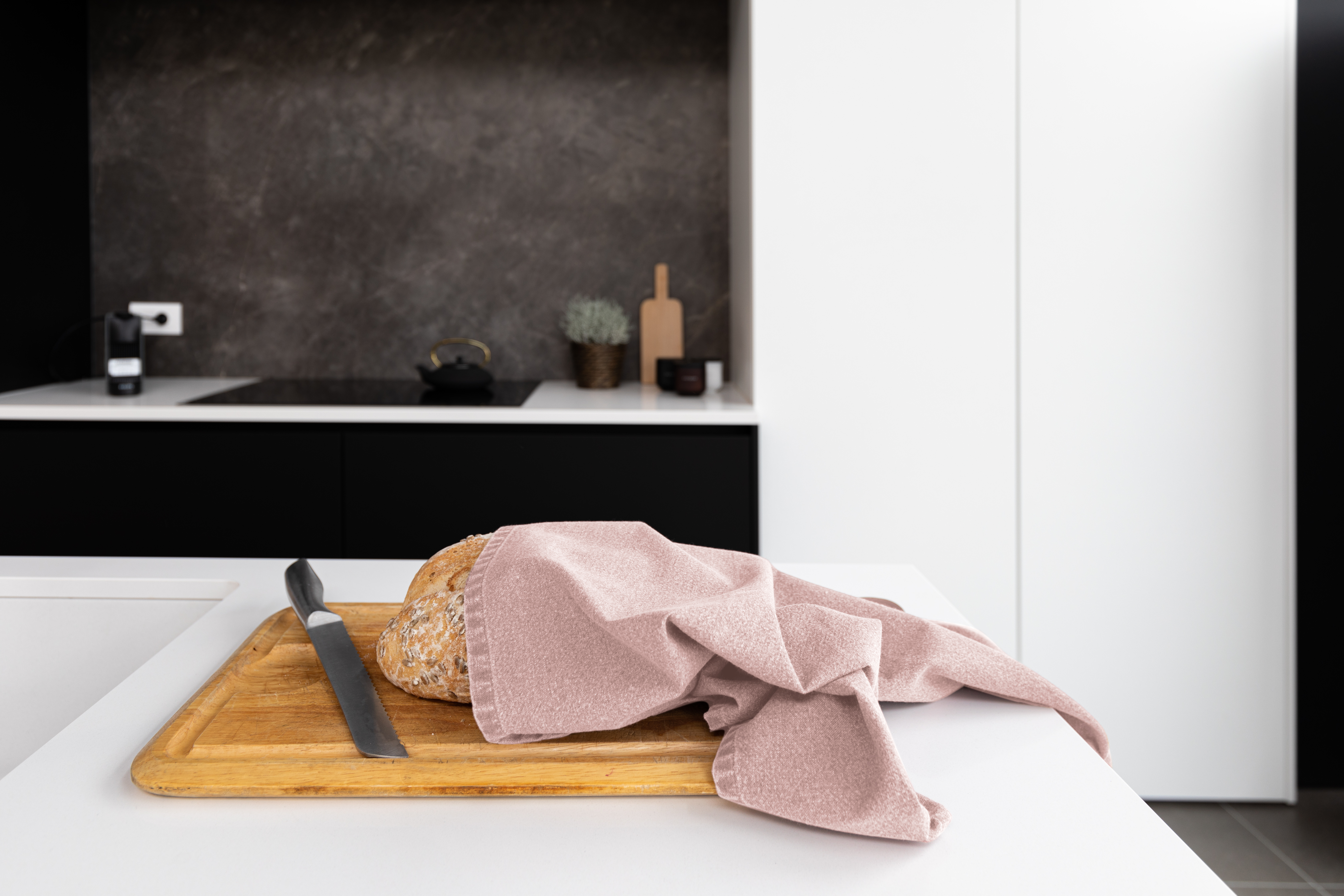 Een keukendoek is om een brood gewikkeld dat op een snijplank is geplaatst