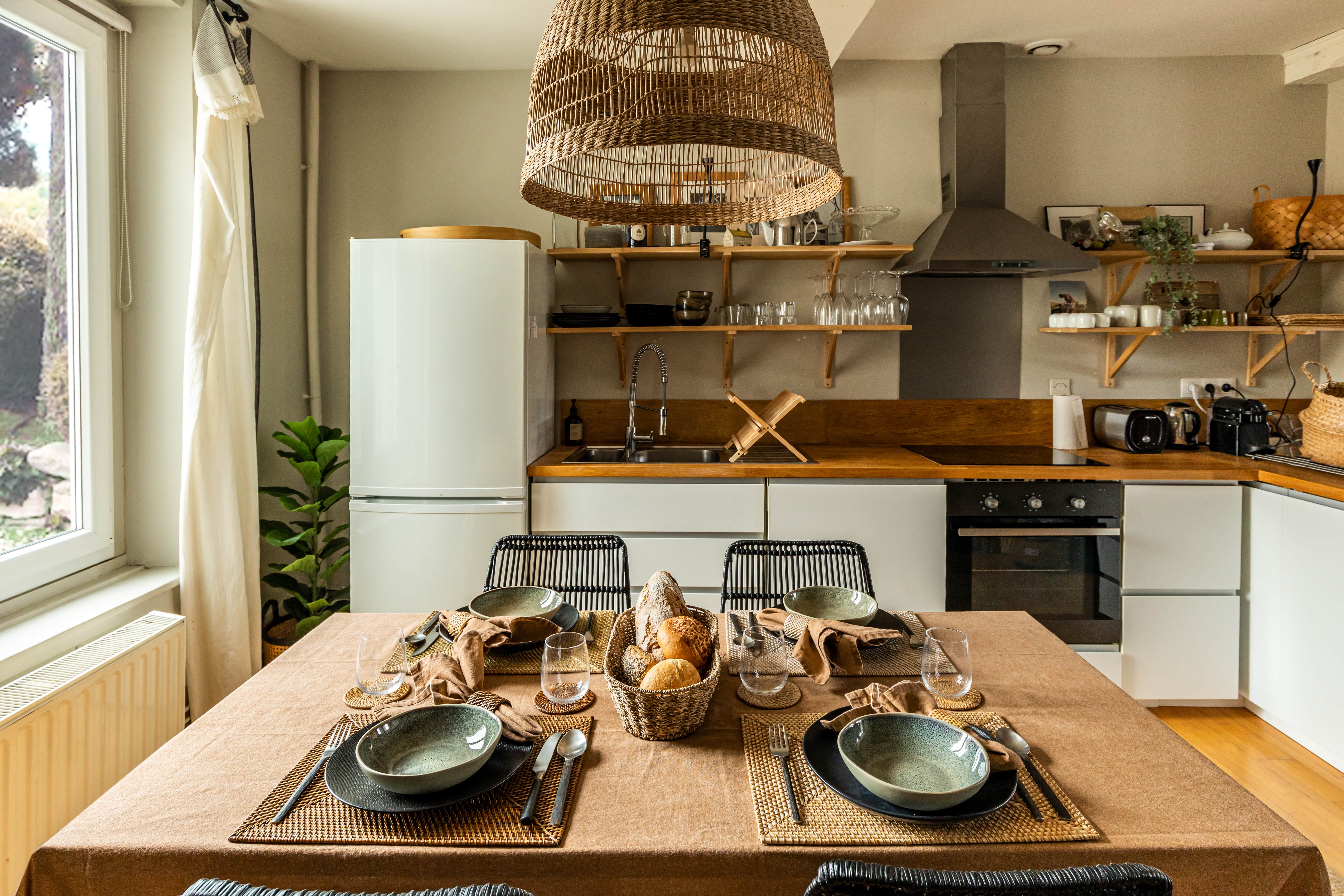 Een gedekte tafel met rechthoekige placemats, glasonderzetters en servet met servetring in Rattan materiaal